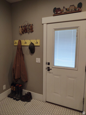2170 Highway 357 Beaver, UT 84713 - Photo 48 of 56 White paneled door with integrated blinds, wall-mounted coat rack, and hexagon tile flooring