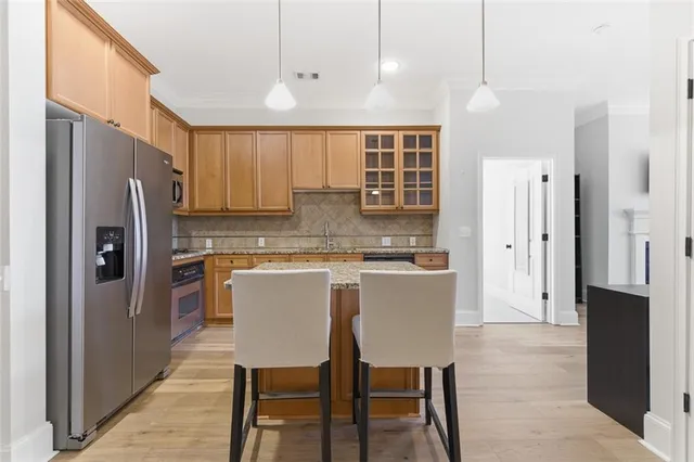 a kitchen with stainless steel appliances granite countertop a sink refrigerator and cabinets