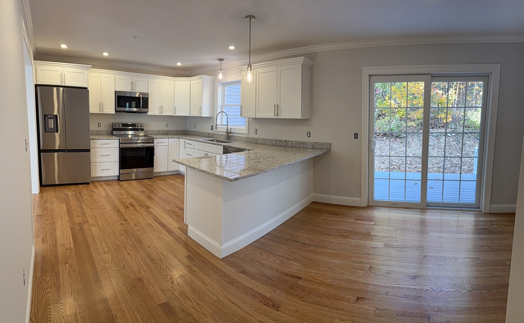 63 North Street, Unit B Worcester, MA 01605 - Photo 17 of 19 a large kitchen with stainless steel appliances granite countertop a stove a sink and a refrigerator