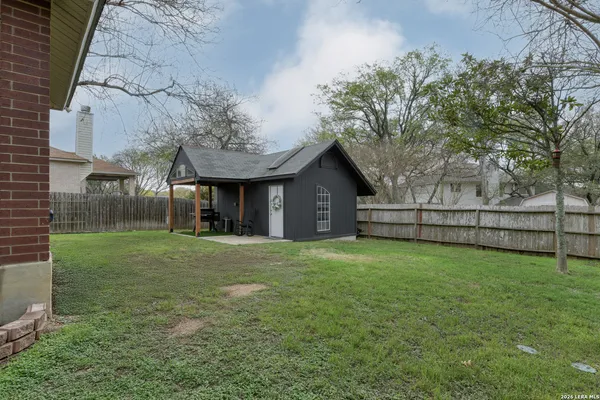 a view of a house next to a yard with wooden fence