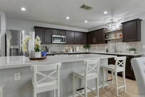 a kitchen with kitchen island granite countertop counter top space cabinets and stainless steel appliances
