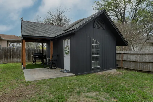 a view of a house with a yard and wooden fence