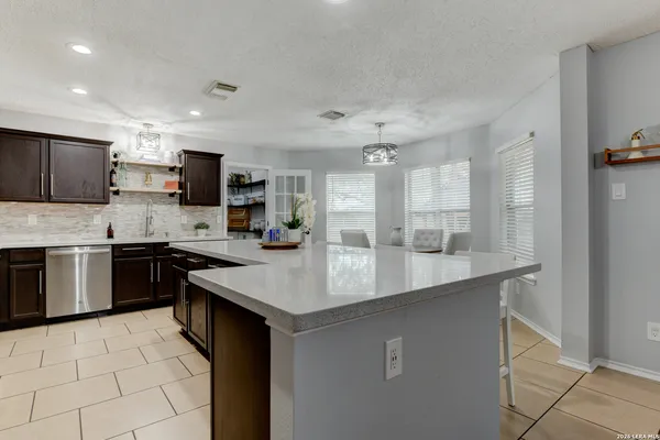 a kitchen with a sink a counter top space cabinets and stainless steel appliances