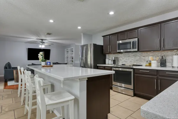 a kitchen with a sink a microwave and cabinets