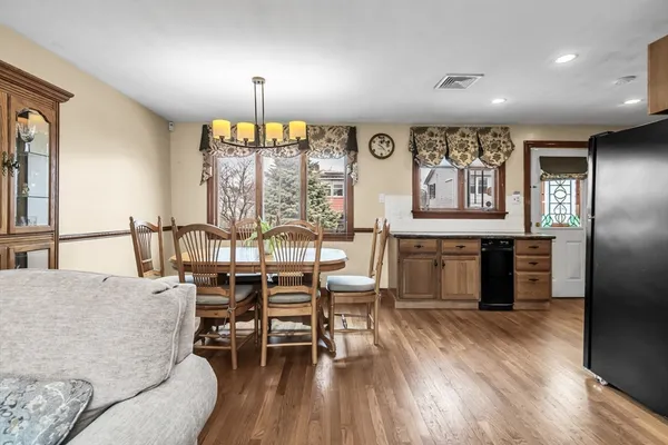 a dining room with furniture window and wooden floor