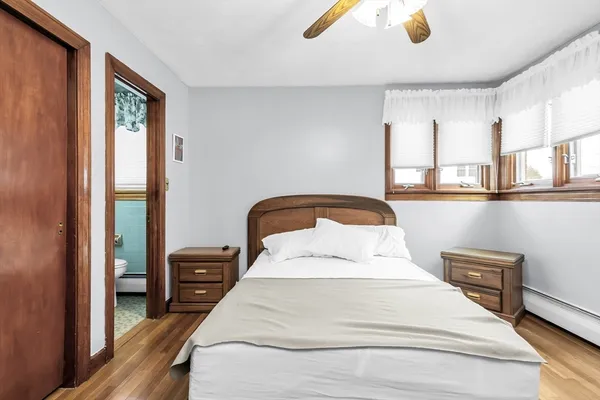 a bedroom with a bed and painting on the wall