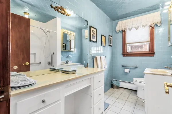 a bathroom with a sink a toilet and a mirror