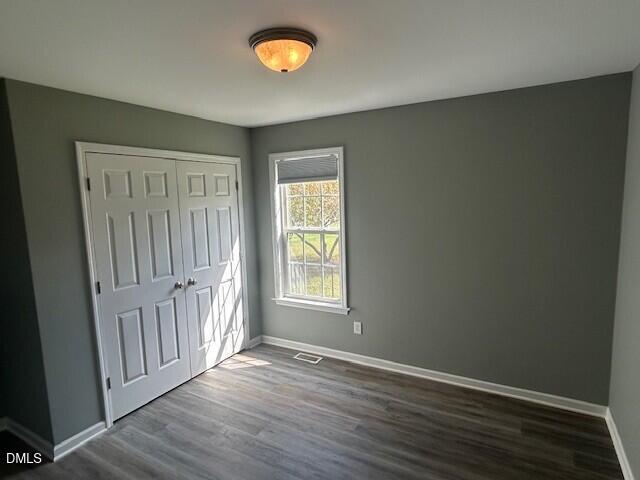 85 Opal Lane Clayton, NC 27520 - Photo 11 of 15 an empty room with wooden floor and windows