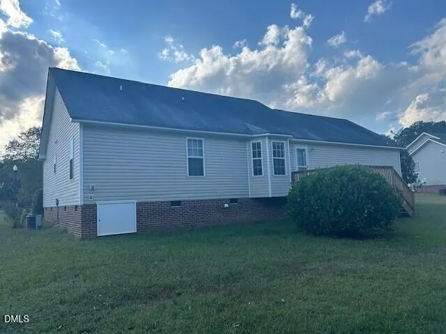 a view of a backyard with potted plants and large trees