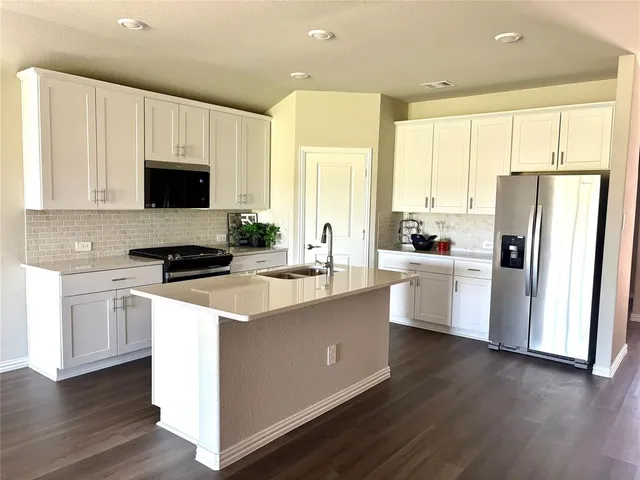 a kitchen with white cabinets and white appliances