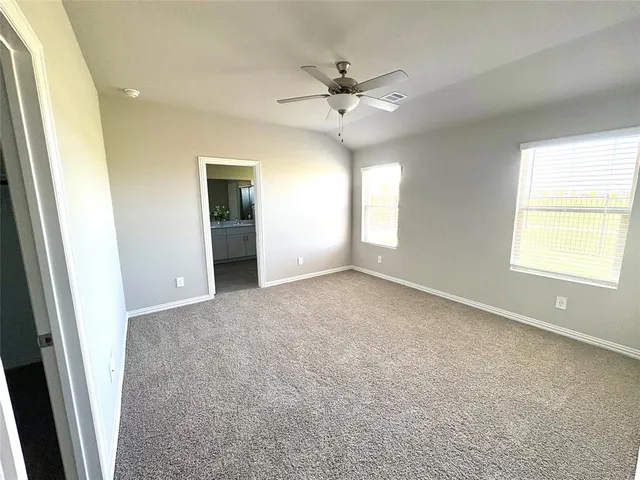 an empty room with windows and fan