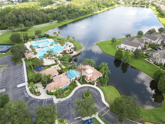 an aerial view of a house with a garden and lake view