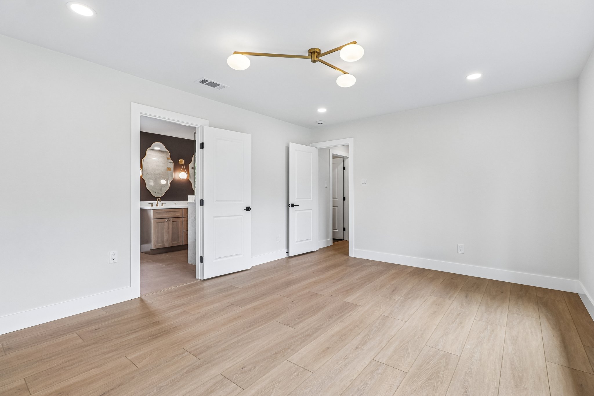 11809 Charing Cross Road Austin, TX 78759 - Photo 13 of 34 Blonde wood flooring spans this light-filled room, offering access to an adjoining bathroom.