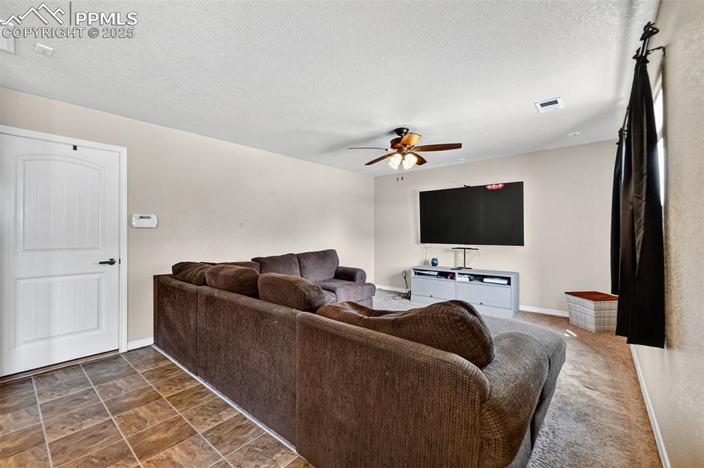 10859 Hidden Ridge Circle Peyton, CO 80831 - Photo 14 of 33 Living room featuring a ceiling fan and a textured ceiling