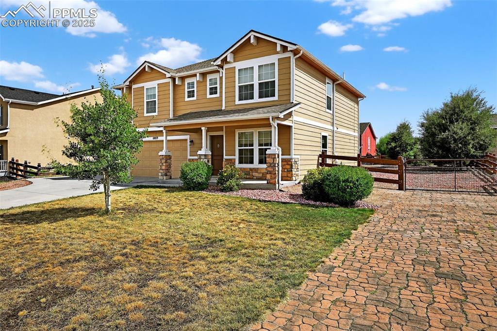 10859 Hidden Ridge Circle Peyton, CO 80831 - Photo 2 of 33 Craftsman-style home with a porch, a garage, stone siding, and concrete driveway