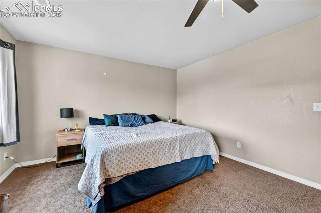 10859 Hidden Ridge Circle Peyton, CO 80831 - Photo 21 of 33 Carpeted bedroom with ceiling fan and baseboards