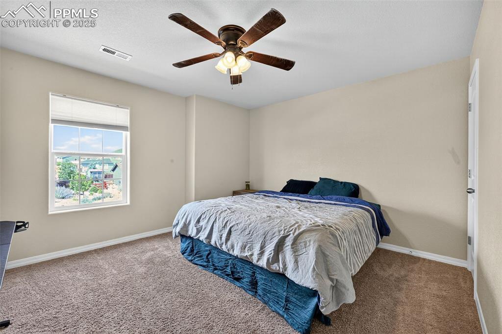 10859 Hidden Ridge Circle Peyton, CO 80831 - Photo 25 of 33 Carpeted bedroom with baseboards and a ceiling fan