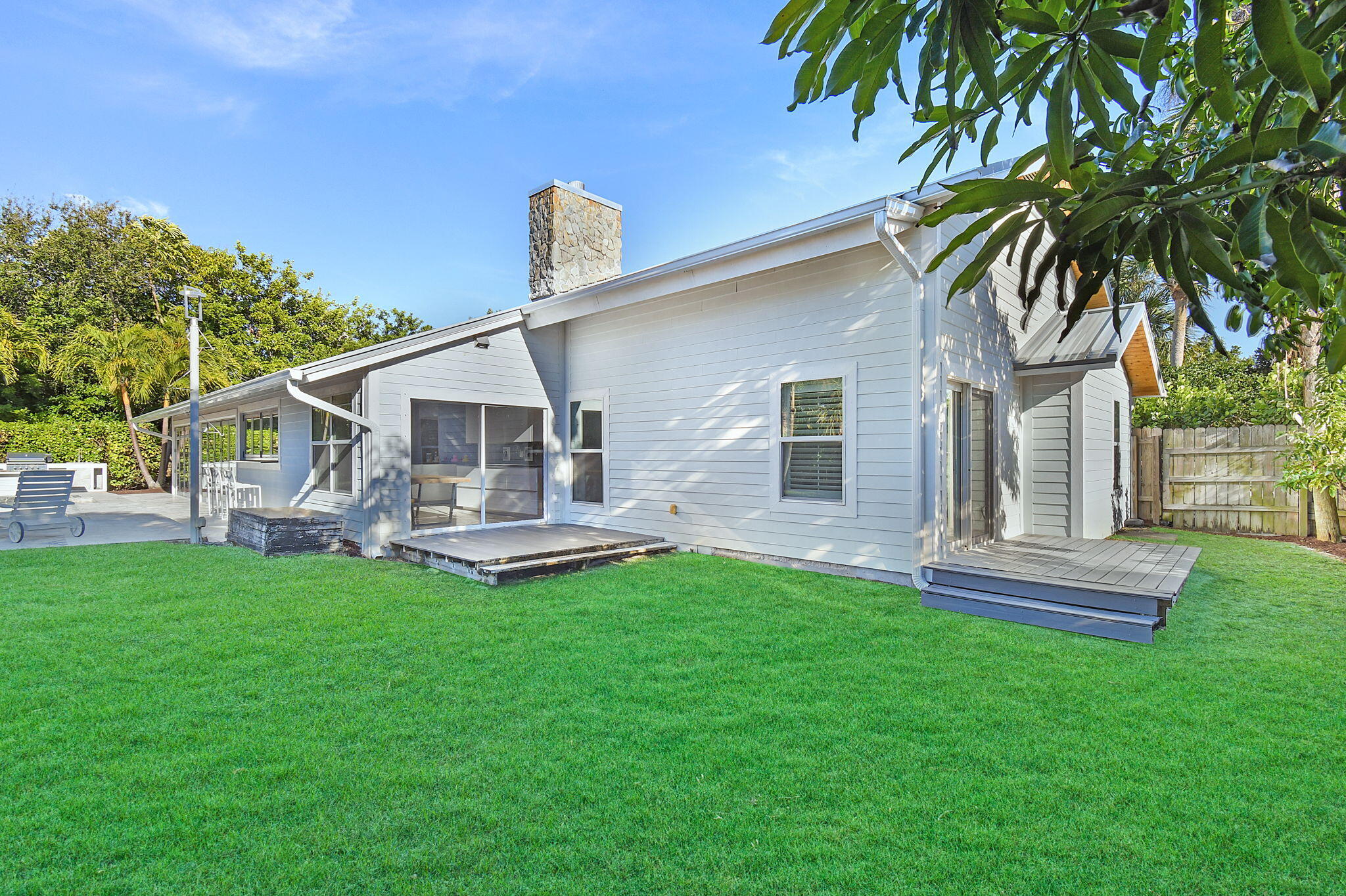 123 Olympus Way Jupiter, FL 33477 - Photo 53 of 116 a front view of a house with a garden and patio