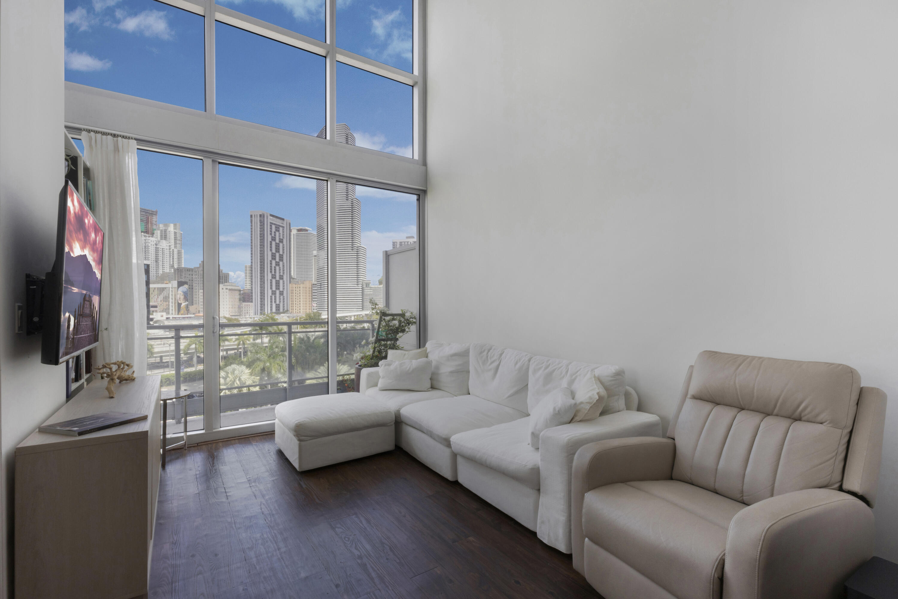90 Southwest 3rd Street, Unit TH700A Miami, FL 33130 - Photo 3 of 32 a living room with furniture and a flat screen tv