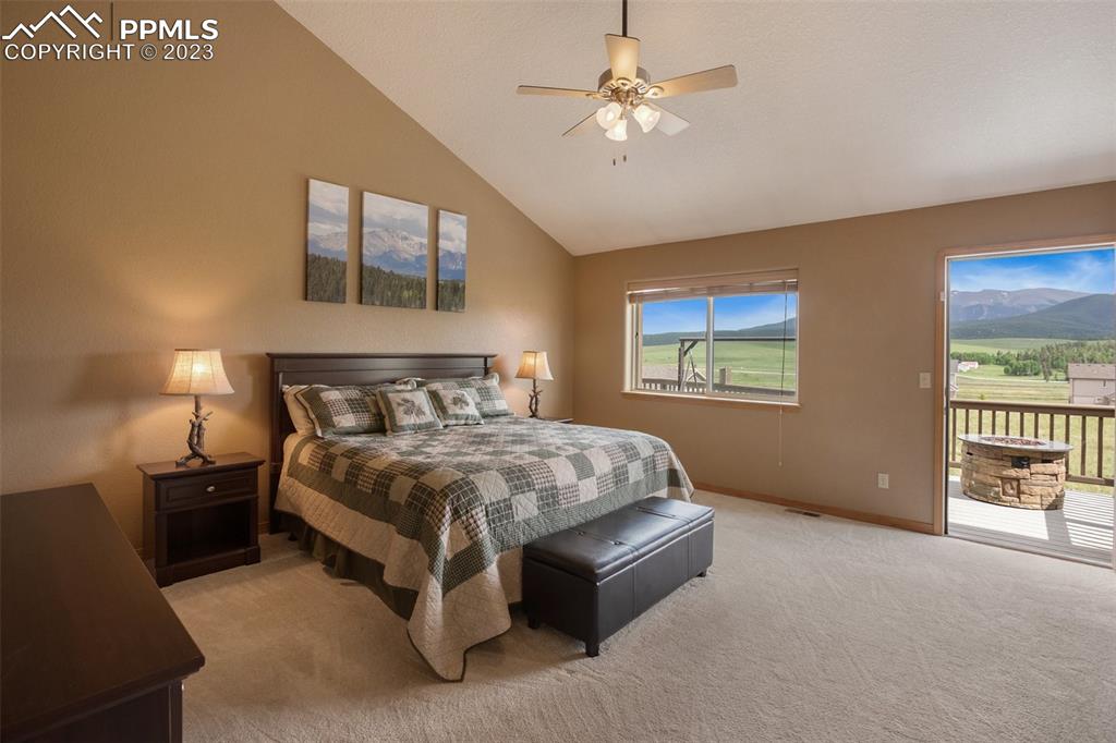 113 Matthew Road Divide, CO 80814 - Photo 16 of 49 a spacious bedroom with a large bed and a chandelier