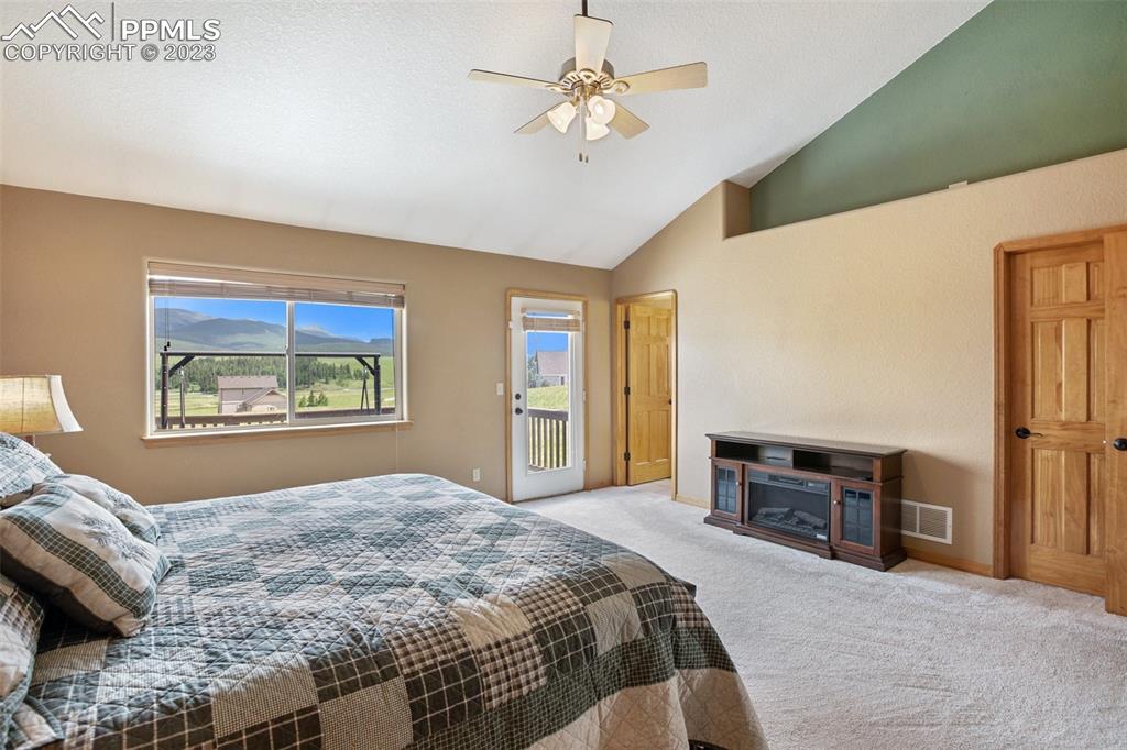 113 Matthew Road Divide, CO 80814 - Photo 18 of 49 a bedroom with a large bed and a chandelier