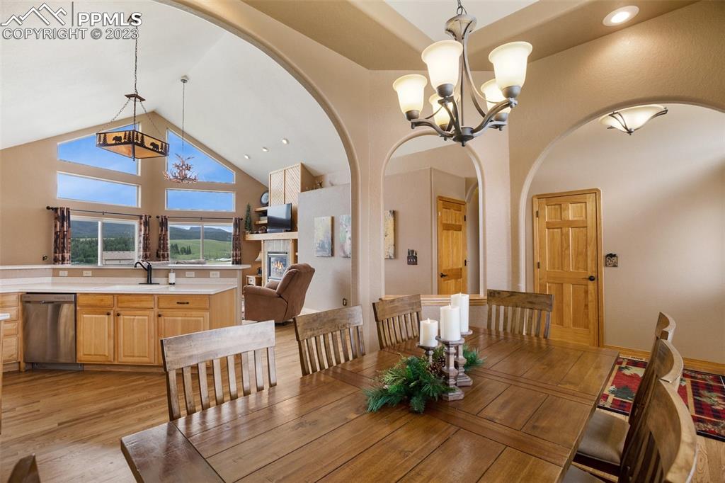 113 Matthew Road Divide, CO 80814 - Photo 9 of 49 a dining room with wooden floor a chandelier a wooden table and chairs