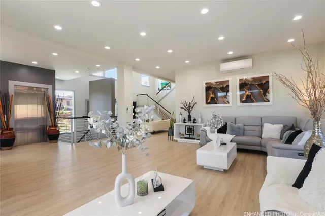 a living room with furniture flowers and a wooden floor