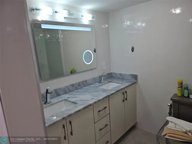 a bathroom with a granite countertop toilet sink and mirror