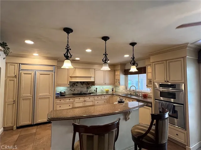 a kitchen with kitchen island granite countertop a sink counter top space appliances and cabinets