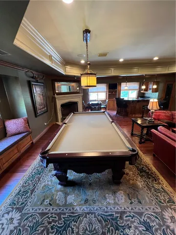an empty room with wooden floor cabinet and windows