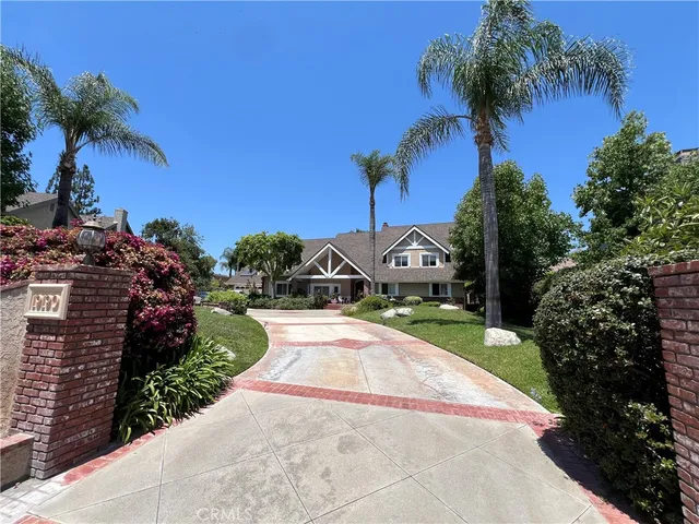 a front view of a house with a yard and potted plants