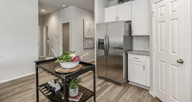 a kitchen with stainless steel appliances granite countertop a refrigerator and a stove top oven