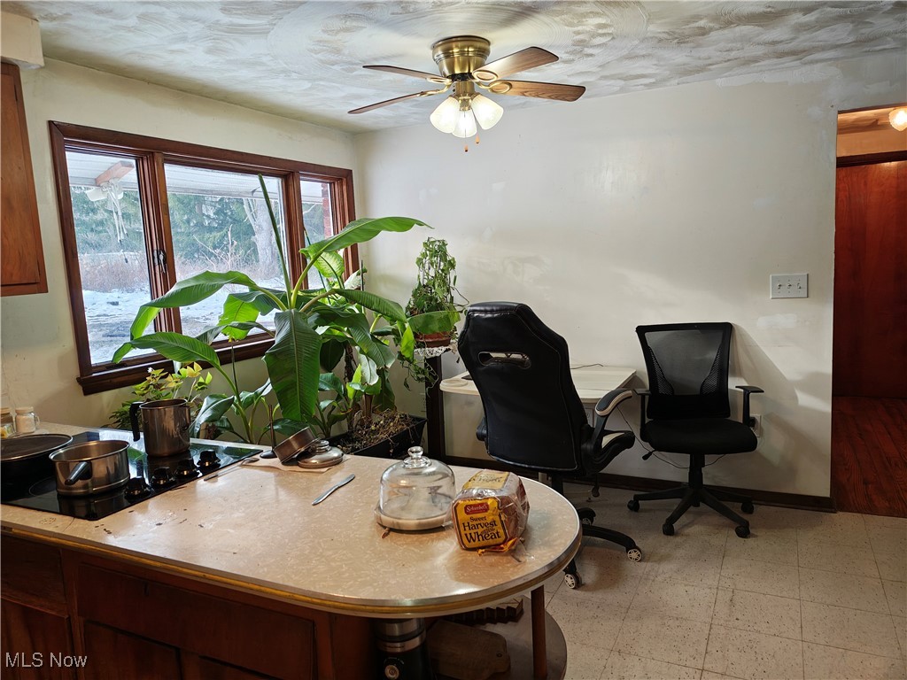 Office area featuring a ceiling fan and light flooring
