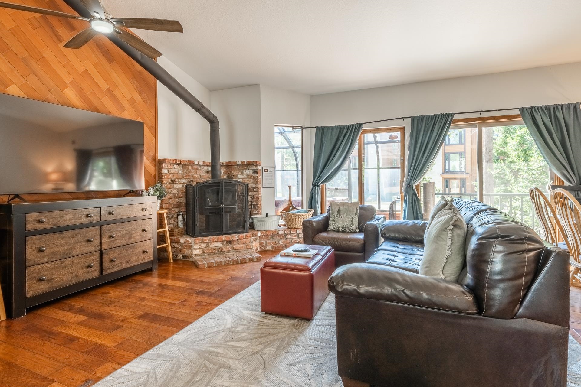 354 Joaquin Road, Unit 4 Mammoth Lakes, CA 93546 - Photo 1 of 40 Living room with a wood stove, wood finished floors, wood walls, and ceiling fan