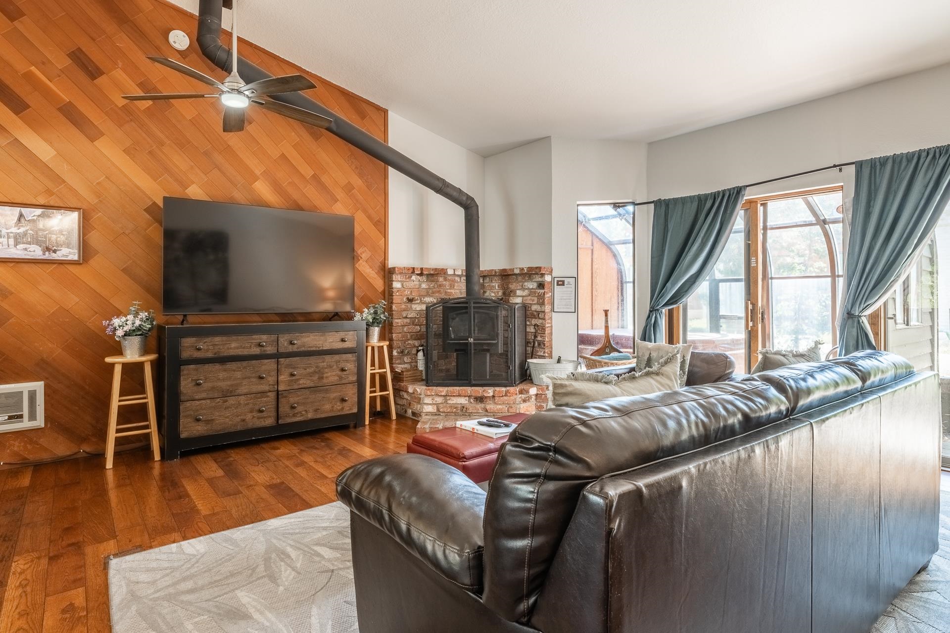 354 Joaquin Road, Unit 4 Mammoth Lakes, CA 93546 - Photo 4 of 40 Living room featuring wood walls, a ceiling fan, a wood stove, and wood finished floors