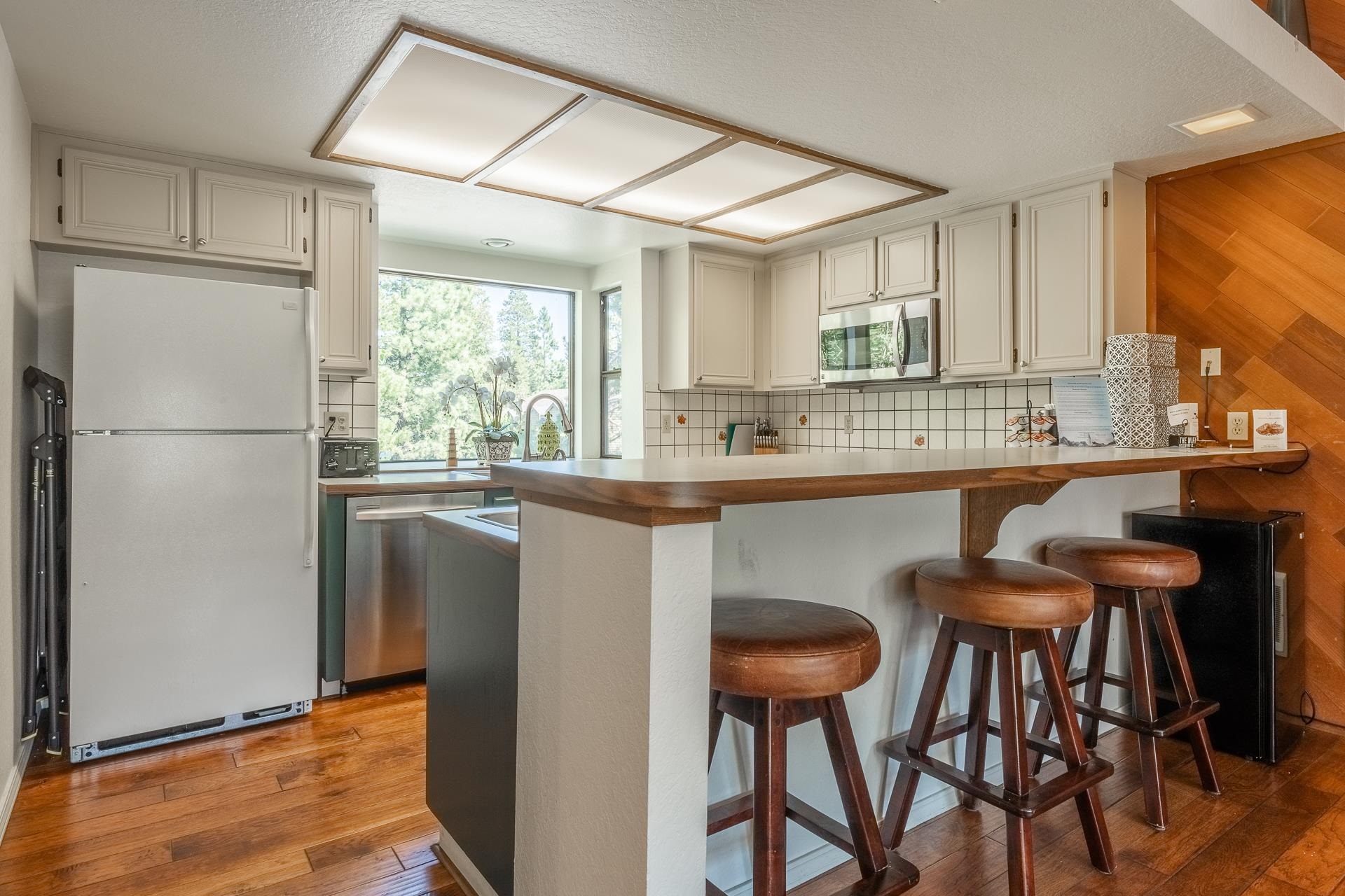 354 Joaquin Road, Unit 4 Mammoth Lakes, CA 93546 - Photo 10 of 40 Kitchen with stainless steel appliances, backsplash, a breakfast bar area, and a peninsula