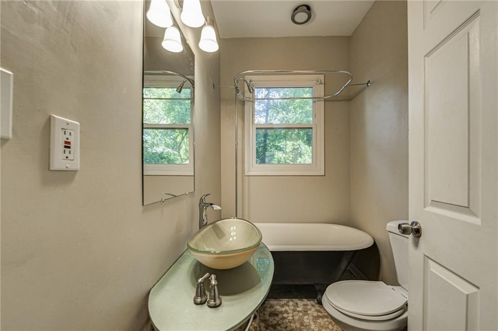 483 Burlington Road Northeast Atlanta, GA 30307 - Photo 16 of 18 a bathroom with a granite countertop toilet sink and mirror