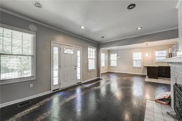 a kitchen with kitchen island a stove a refrigerator a sink dishwasher with a dining table and chairs with wooden floor