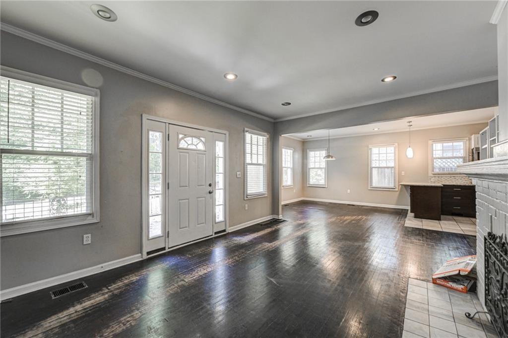 483 Burlington Road Northeast Atlanta, GA 30307 - Photo 5 of 18 a view of an empty room with a window and wooden floor