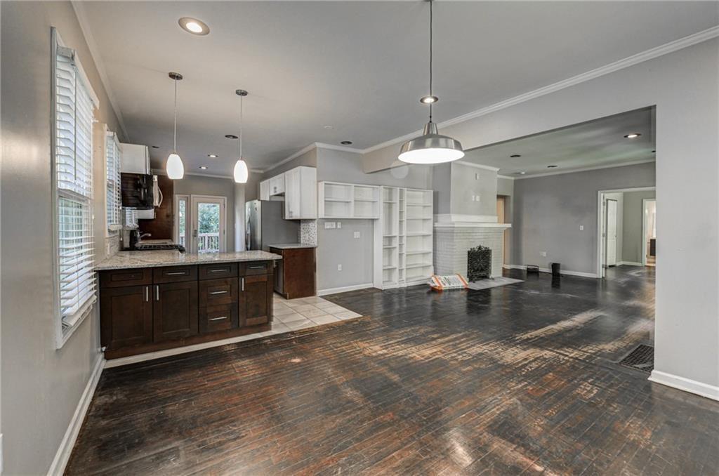 483 Burlington Road Northeast Atlanta, GA 30307 - Photo 6 of 18 a kitchen with kitchen island a stove a refrigerator a sink dishwasher with a dining table and chairs with wooden floor