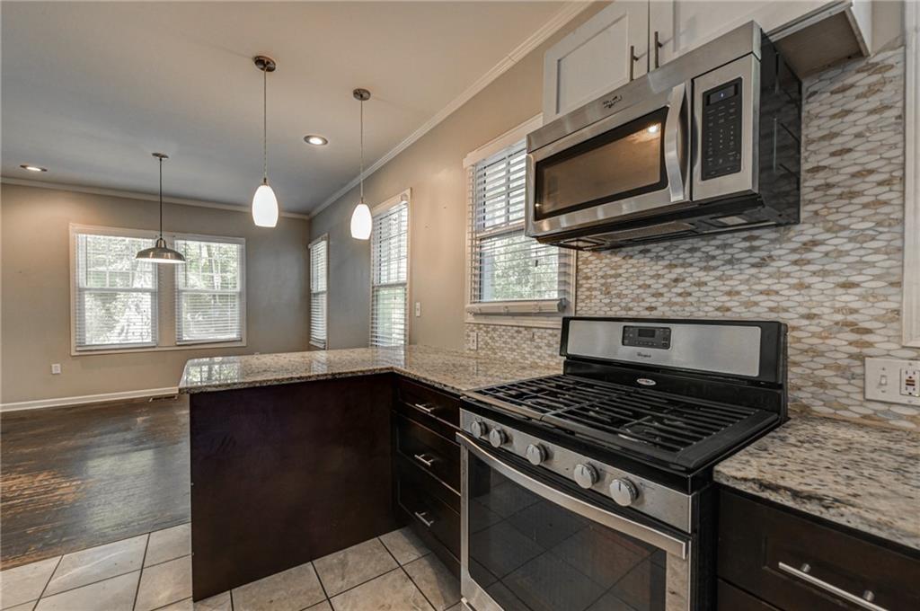 483 Burlington Road Northeast Atlanta, GA 30307 - Photo 9 of 18 a kitchen with stainless steel appliances granite countertop a stove a sink and a microwave