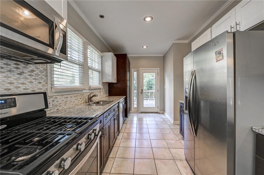 483 Burlington Road Northeast Atlanta, GA 30307 - Photo 10 of 18 a kitchen with stainless steel appliances granite countertop a stove a refrigerator and a sink
