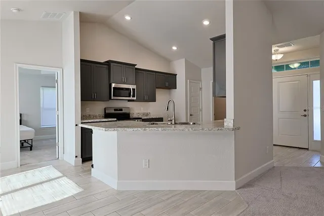 a kitchen with stainless steel appliances granite countertop a refrigerator and a stove