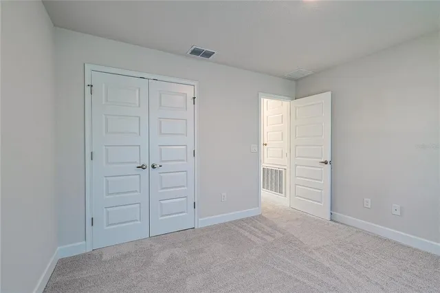 an empty room with closet and natural light