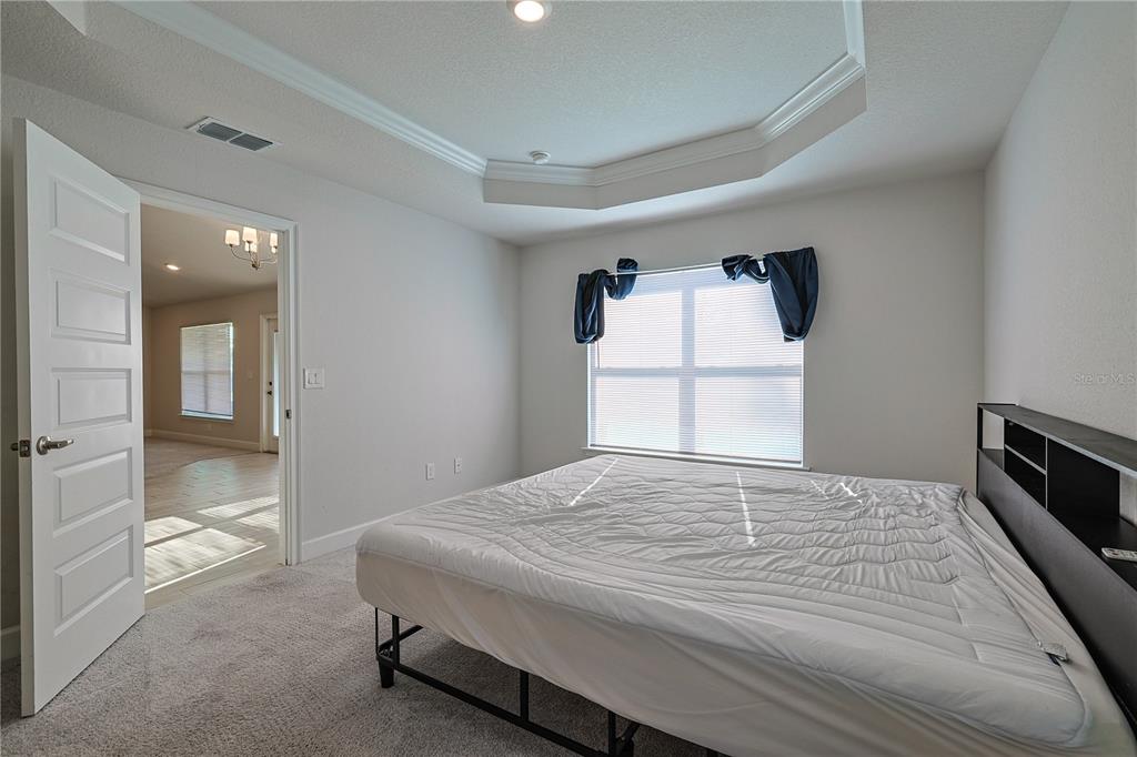 10939 Southwest 41st Avenue Ocala, FL 34476 - Photo 31 of 40 a bedroom with a bed and a large mirror