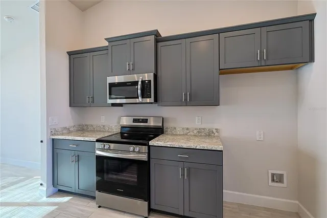 a kitchen with stainless steel appliances granite countertop a stove microwave and sink