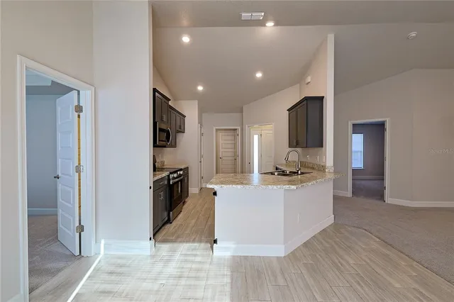 a large kitchen with a sink and stainless steel appliances