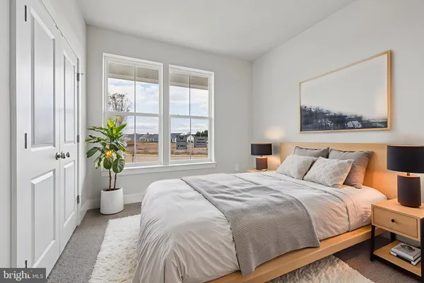 a bedroom with a bed and a large window