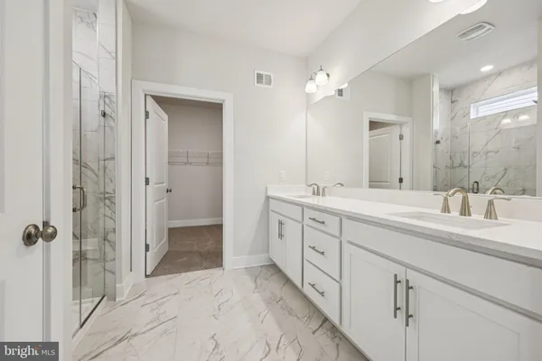 a spacious bathroom with a double vanity sink mirror and shower