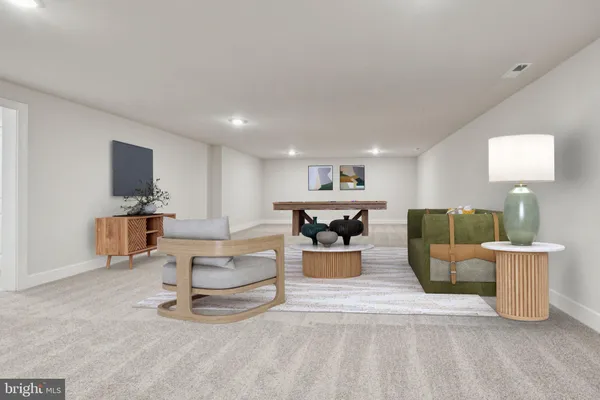 a living room with furniture a flat screen tv and a view of kitchen